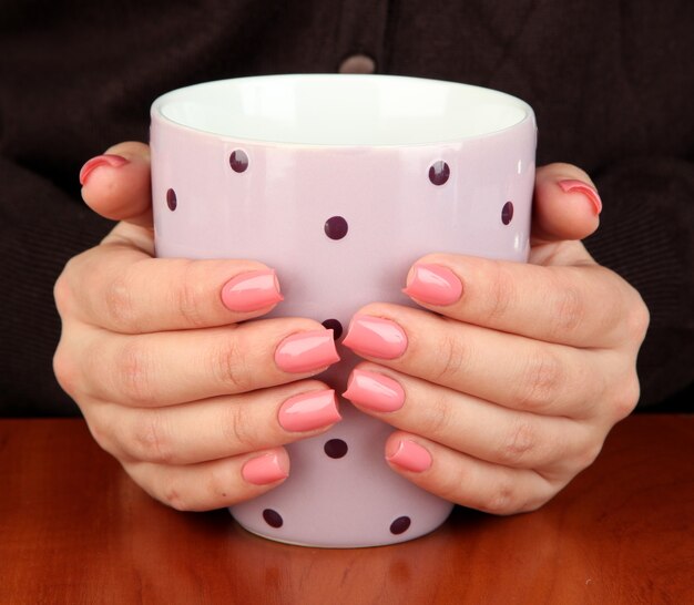 Hands holding mug of hot drink, close-up