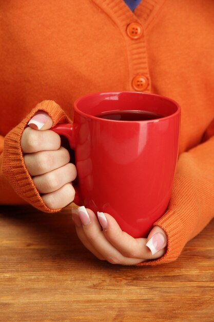 Hands holding mug of hot drink, close-up