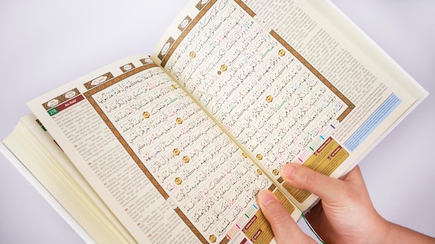 Hands Holding an Open Holy Quran From Above