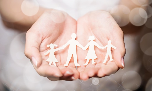 Hands holding paper cut family