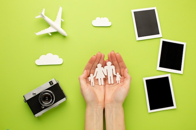 Hands holding paper family next to instant photos