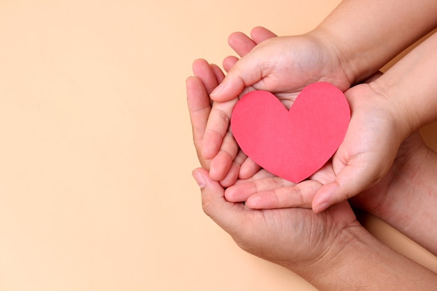 hands holding paper red heart,Concept of health in the family.