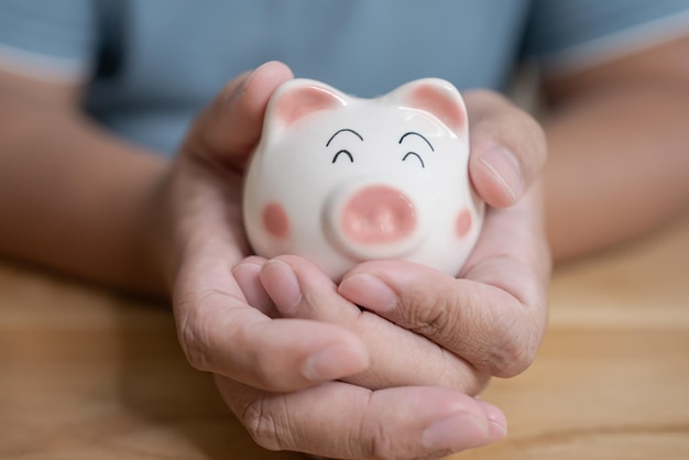 Hands holding piggy bank Saving concept with piggy bank indoor