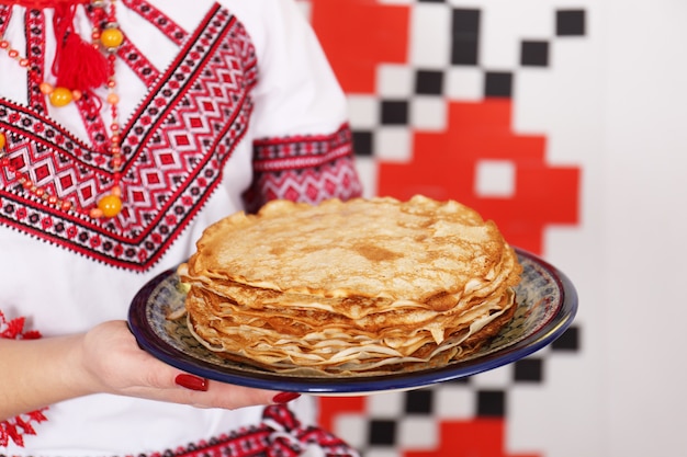 Hands holding a plate of pancakes