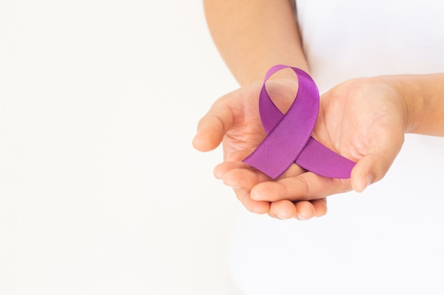 Photo hands holding purple or violet ribbon on white background