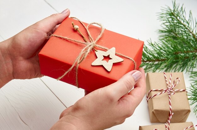 Hands holding red christmas gift box