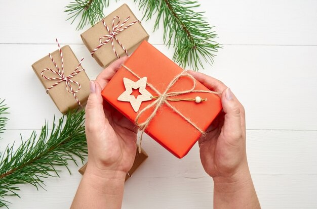 Hands holding red Christmas gift box