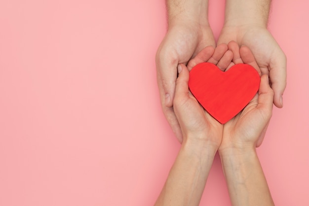 Photo hands holding red heart close up