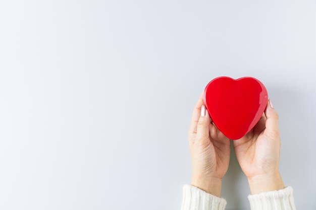 Hands holding red heart. - health care, love, organ donation, mindfulness, wellbeing, concept. - world heart day, world health day, National Organ Donor Day.