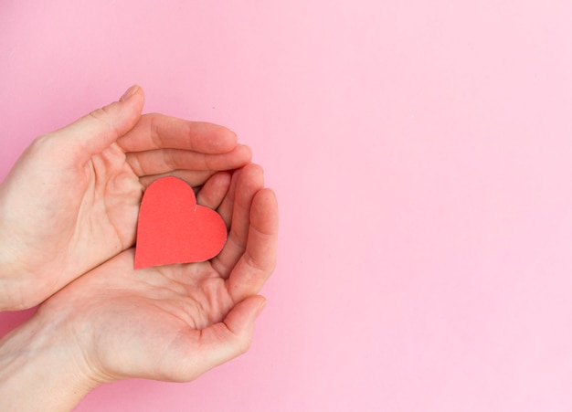 Hands holding red heart, heart health, donation, happy\
volunteer charity, csr social responsibility,world heart day, world\
health day,world mental health day,foster home, wellbeing, hope\
concept