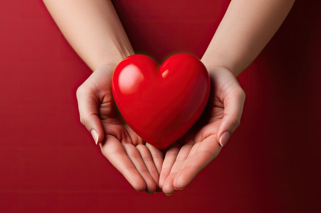 A hands holding a red heart on a red background