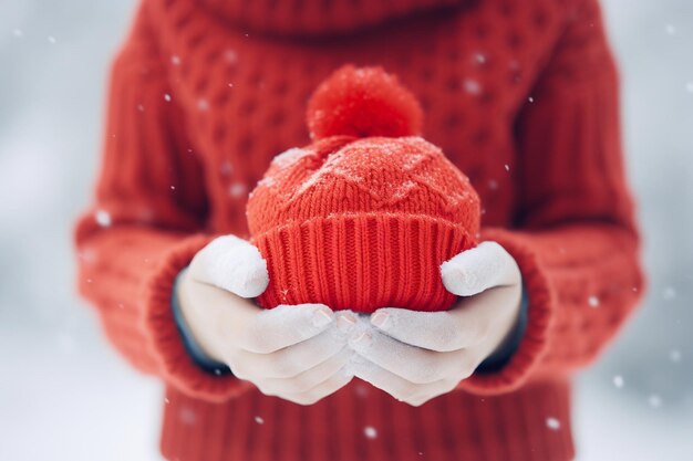 Hands Holding Red Piggy Bank in Warm Hat Outdoors Generative Ai