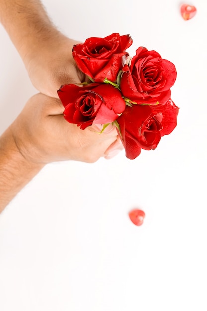 赤いバラを保持している手