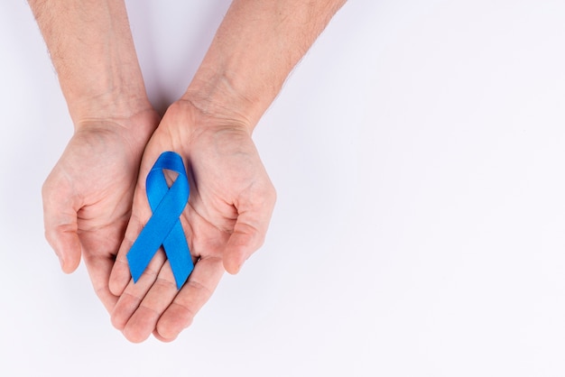 Hands holding ribbon as symbol for awareness