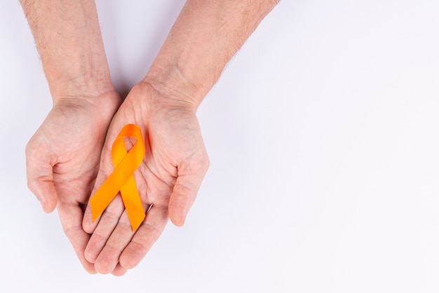 Hands holding ribbon as symbol for awareness