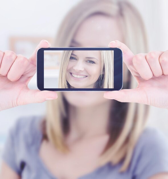 Photo hands holding smartphone against portrait of beautiful woman smiling at home