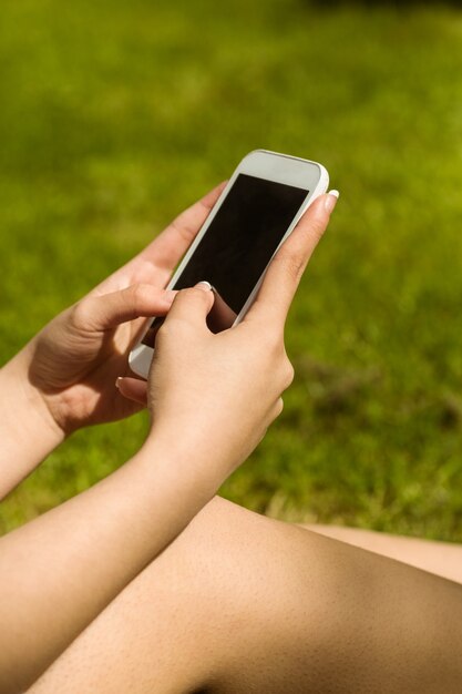 Hands holding smartphone in park