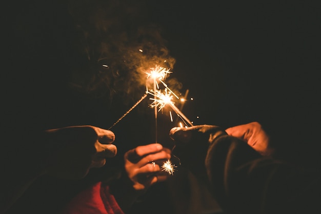 hands holding sparklers for celebrate in the night time