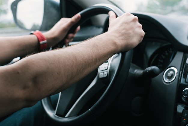 Hands holding steering wheel. Learning to drive a car.