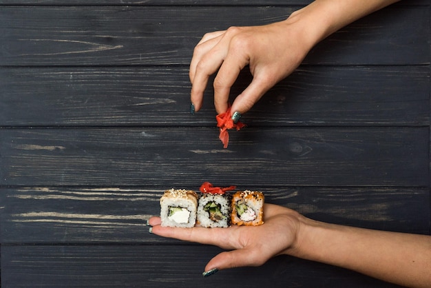 Hands holding sushi and raspberry ginger 2