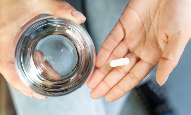 Photo hands holding tablet and glass with water responsible use of medication vitamin supplementation