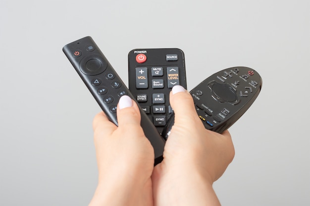 Hands holding tv remote controls