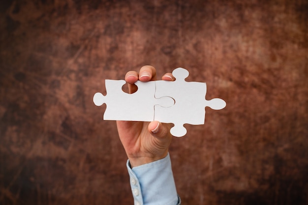 Hands Holding Two Pieces Of Jigsaw Puzzle.Cooperation For Finding And Resolving Missing Ideas At Work.Businessman Find Strategy For Resolving, Connecting Thoughts