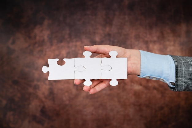 Hands Holding Two Pieces Of Jigsaw Puzzle.Cooperation For Finding And Resolving Missing Ideas At Work.Businessman Find Strategy For Resolving, Connecting Thoughts