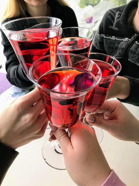 Foto mani che reggono un bicchiere di vino con vino rosso