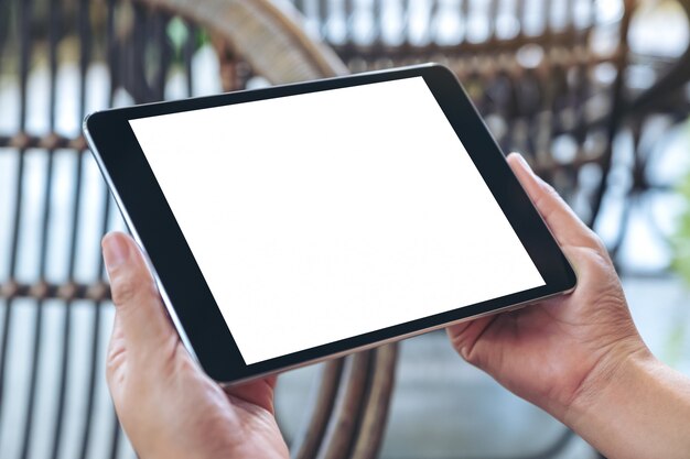  hands holding and using black tablet pc with blank white desktop screen while sitting in the outdoors