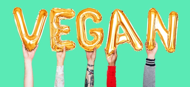 Hands holding vegan word in balloon letters