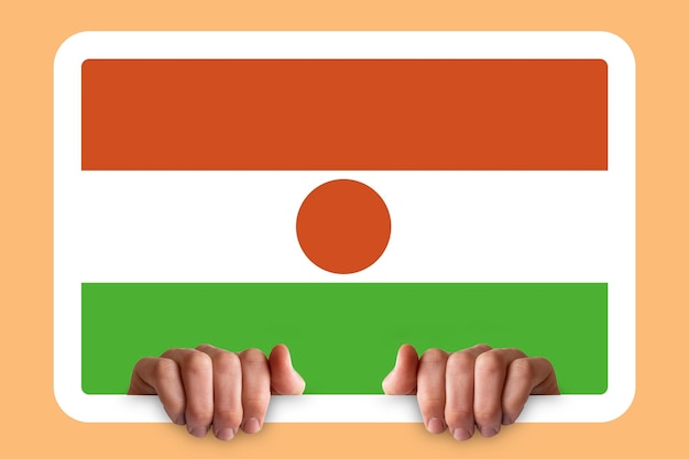 Photo hands holding a white frame with niger flag protest or social issues in niger two hands