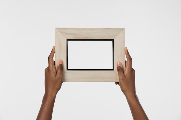 Photo hands holding wooden thick frame