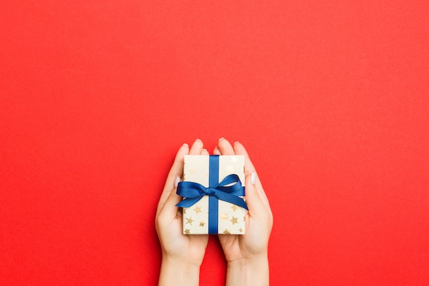 hands holding wrapped present with ribbon