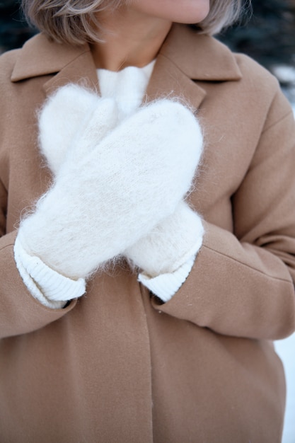 Фото Руки в вязаных варежках. зимний образ жизни. носить стильную теплую одежду. женщина в теплой одежде