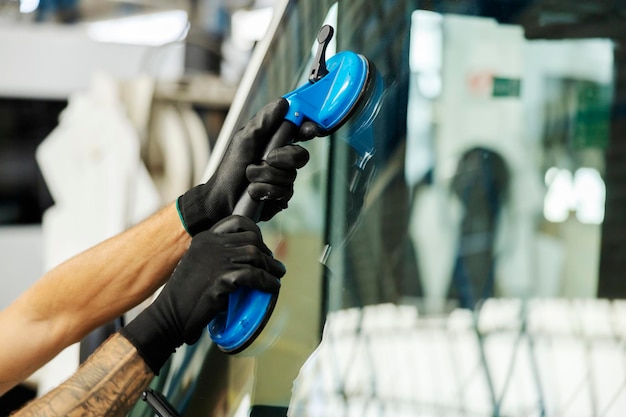 Foto mani che installano il vetro in officina