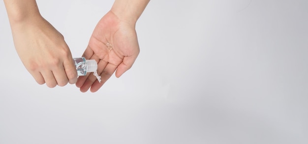 Hands is hold and squeezing alcohol hand gel on white background. Top eye view.