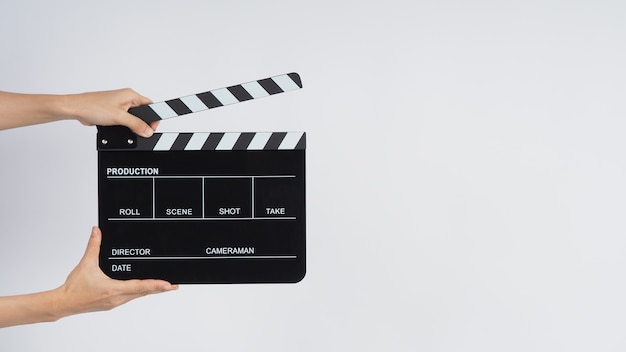 Hands is holding black Clapperboard or movie slate. it use in video production ,film, cinema industry on white background.