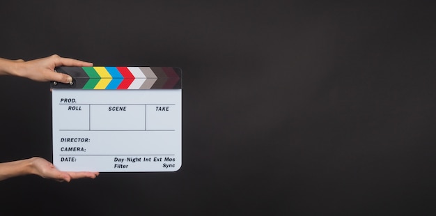 Hands is holding Clapperboard or movie slate. it use in video production ,film, cinema industry on black background.