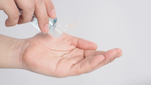 Hands is squeezing alcohol hand gel on white background.