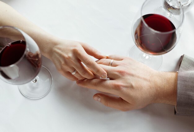 Hands of just married couple  tenderly holding each other, wearing wedding rings