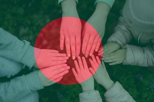 Hands of kids on background of Bangladesh flag Bangladeshi patriotism and unity concept