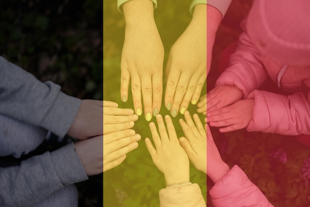 벨기에 국기의 배경에 있는 아이들의 손 벨기에 애국심과 화합 개념