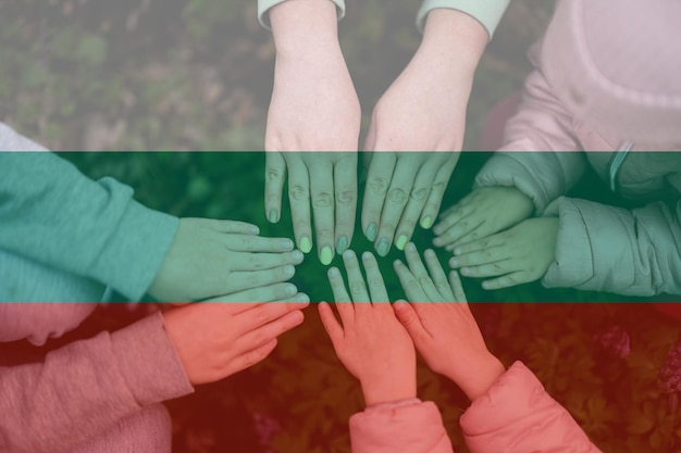 Hands of kids on background of Bulgaria flag Bulgarian patriotism and unity concept