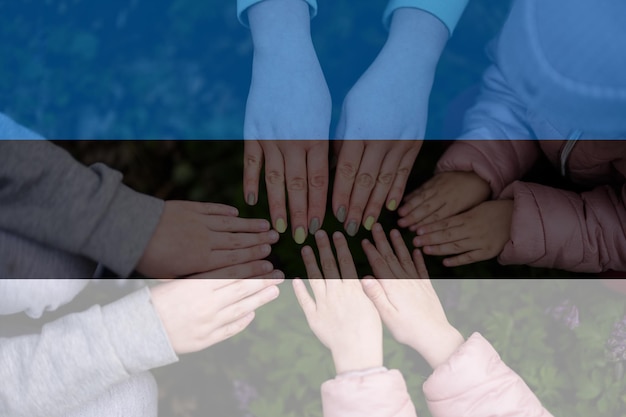 Hands of kids on background of Estonia flag Estonian patriotism and unity concept