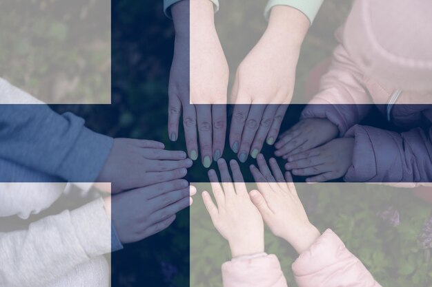 Hands of kids on background of Finland flag Finnish patriotism and unity concept