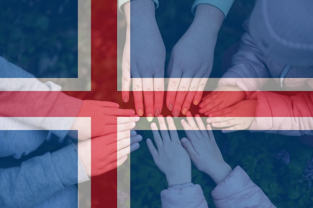 Hands of kids on background of Iceland flag Icelander patriotism and unity concept