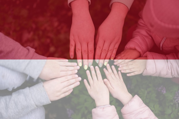 Hands of kids on background of Monaco flag Monegasque patriotism and unity concept