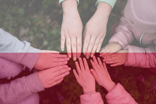 Hands of kids on background of Poland flag Polish patriotism and unity concept