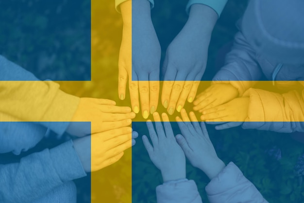 Hands of kids on background of sweden flag swedish patriotism and unity concept